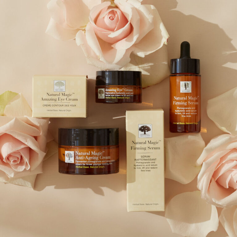 Products from the Natural Magic™ series displayed with light pink roses.
