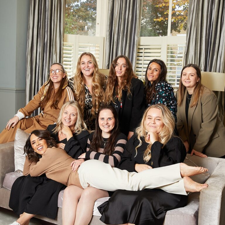 Women posing together on a sofa.