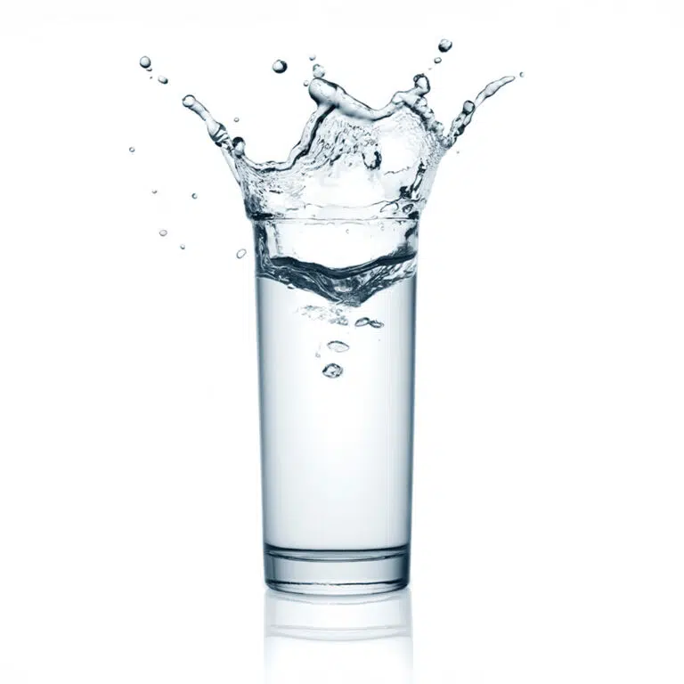 Glass of water splashing, clear refreshing drink in motion