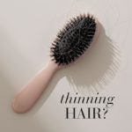 Pink hair brush with hair strands and text thinning hair.