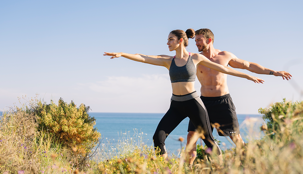 a man and woman standing in grass doing exercises for their health