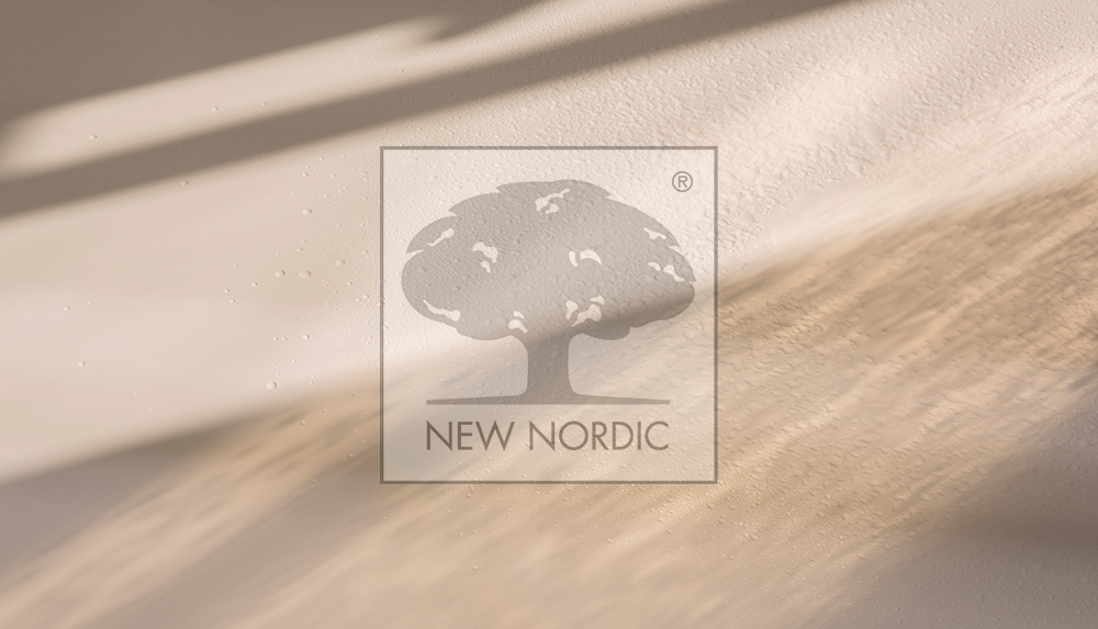 The New Nordic logo displayed on a beige wall with soft sunlight.