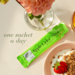 A single Apple Cider™ Shot sachet displayed in a cozy breakfast setting with text One sachet a day.