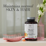 The Biotin™ Gummies bucket displayed with a pink hair brush and text Maintains normal skin and hair.