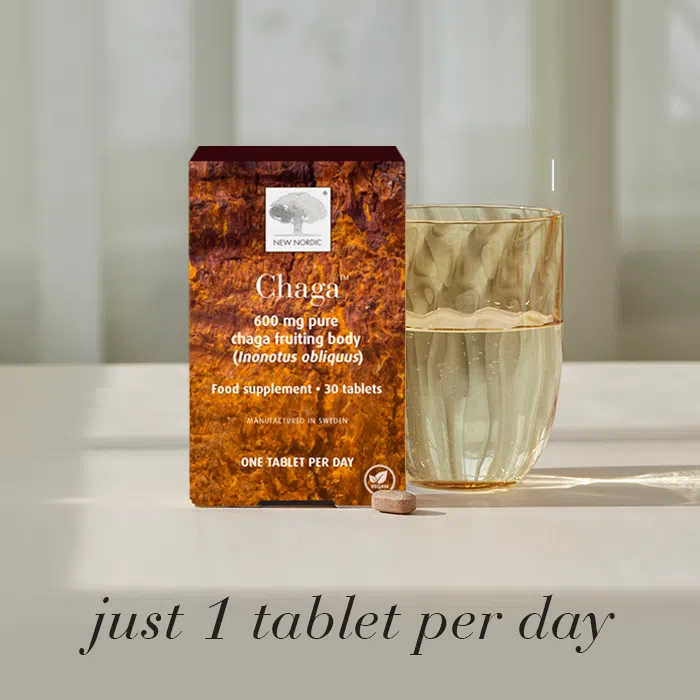 The Chaga™ package displayed with a glass of water and a tablet with text Just 1 tablet per day.