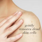 Close-up of a woman rubbing her shoulder with body scrub displayed with text Gently removes dead skin cells.