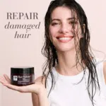 Beautiful woman with wet hair holding the Hair Volume™ Repair Mask, representing healthy shine and strength, with text repair damaged hair