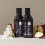 Hair Volume Shampoo and Conditioner next to apples and flowers