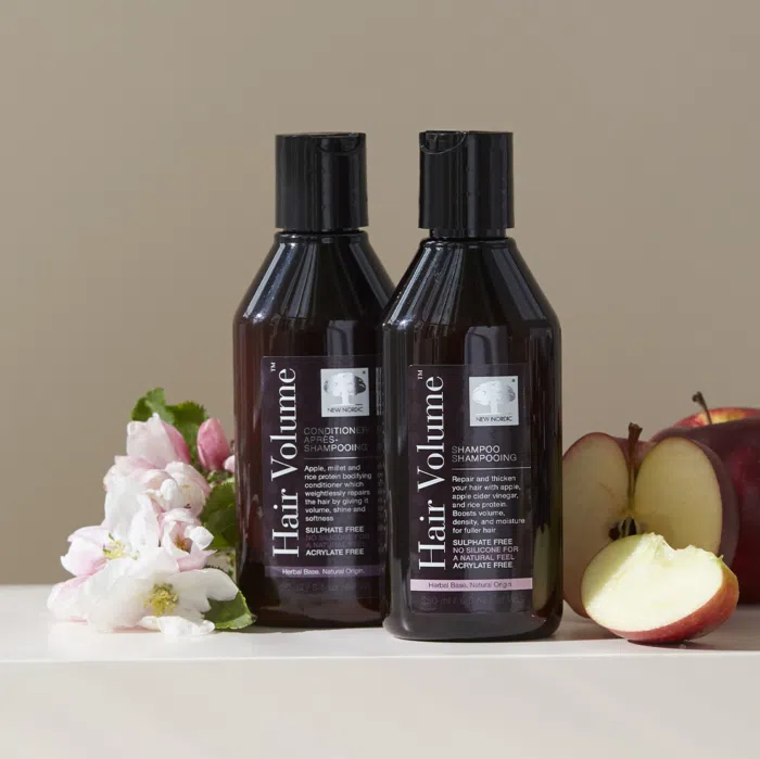 Hair Volume Shampoo and Conditioner next to apples and flowers