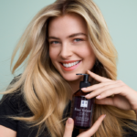 Woman with beautiful, luscious hair holding the Hair Volume™ Shampoo bottle.