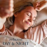 Woman resting in bed with eyes closed and smiling, conveying relaxation and a calm day-and-night routine.
