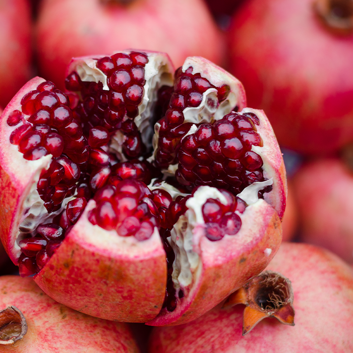 Fresh pomegranate, one cut open to show seeds