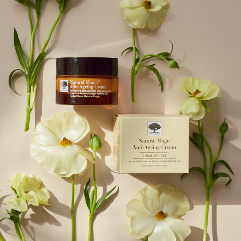 Natural Magic™ Anti-Ageing Cream surrounded by fresh flowers.