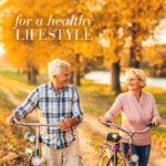Elderly couple walking with their bikes in autumn nature with text For a healthy lifestyle.