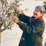 Older lady cutting a tree smiling