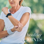 Woman stretching her arm outdoors, highlighting joint mobility and an active, healthy lifestyle.