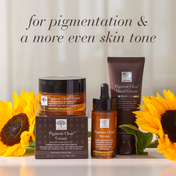 The Pigment Clear cream, serum and hand cream for dark spot correction and even skin tone, styled with sunflowers.