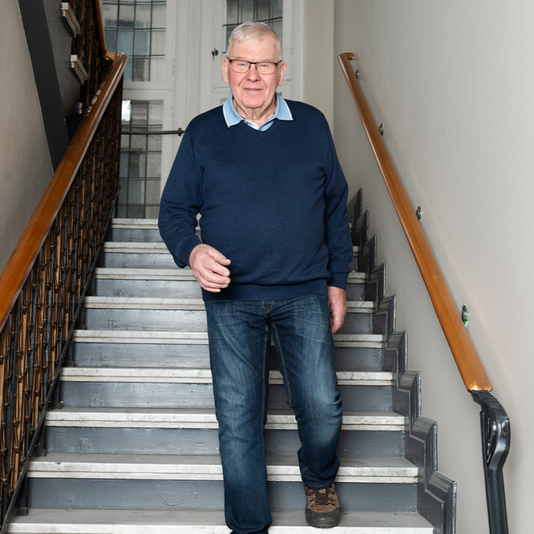 Man walking down the stairs, smiling with no pain