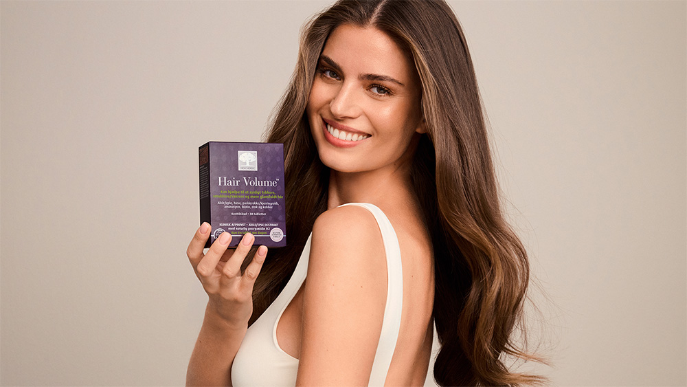 woman with beautiful hair holding hair volume products.