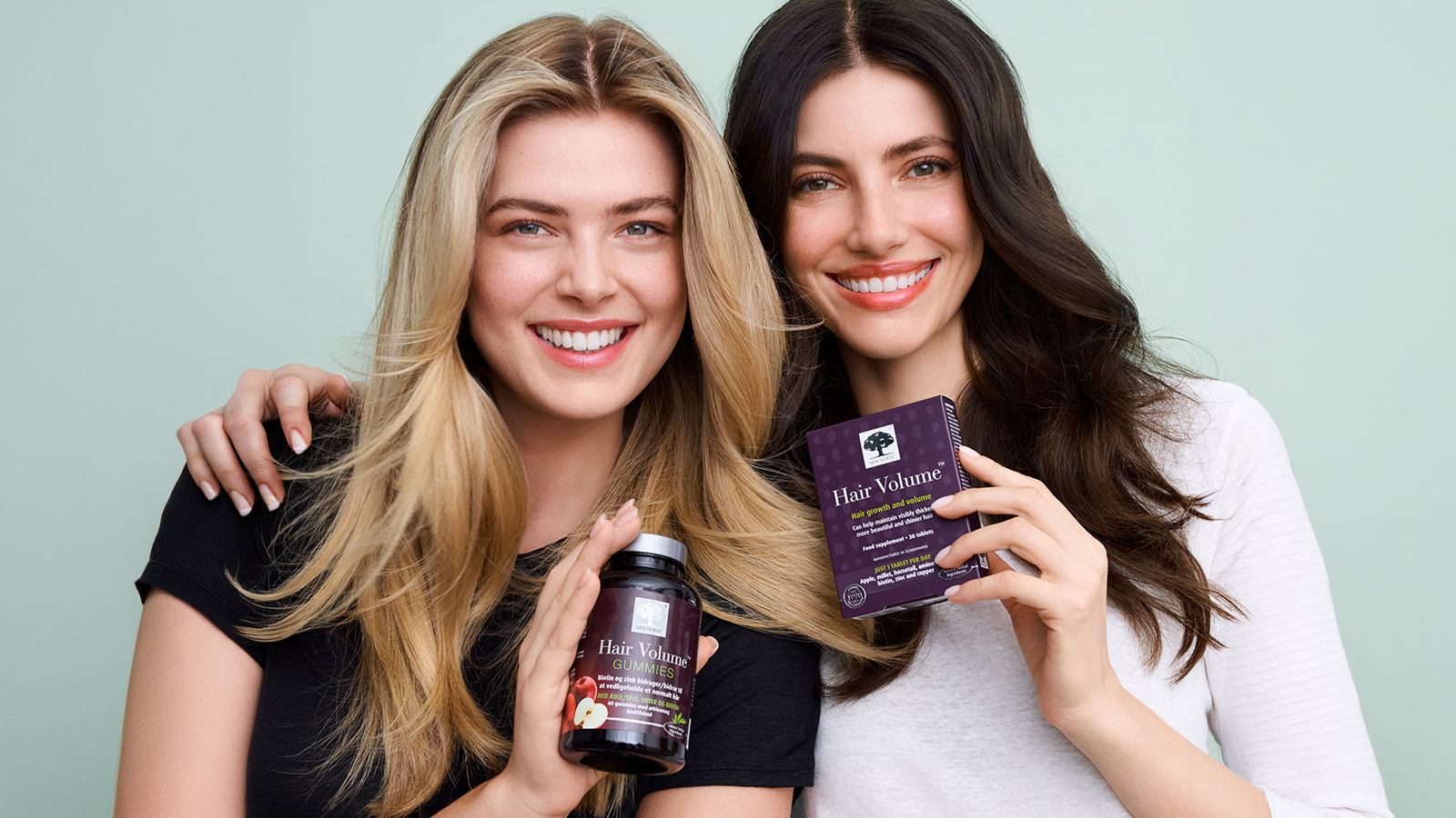 Two women with beautiful hair holding hair volume products.
