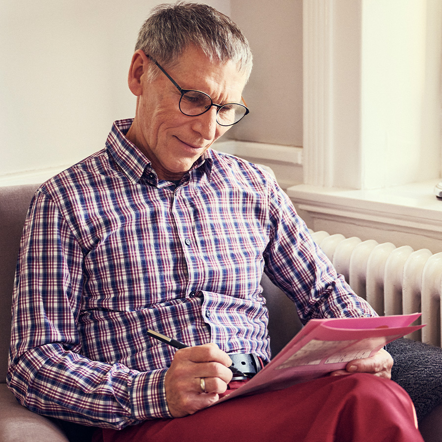 Man doing a puzzle in a magazine