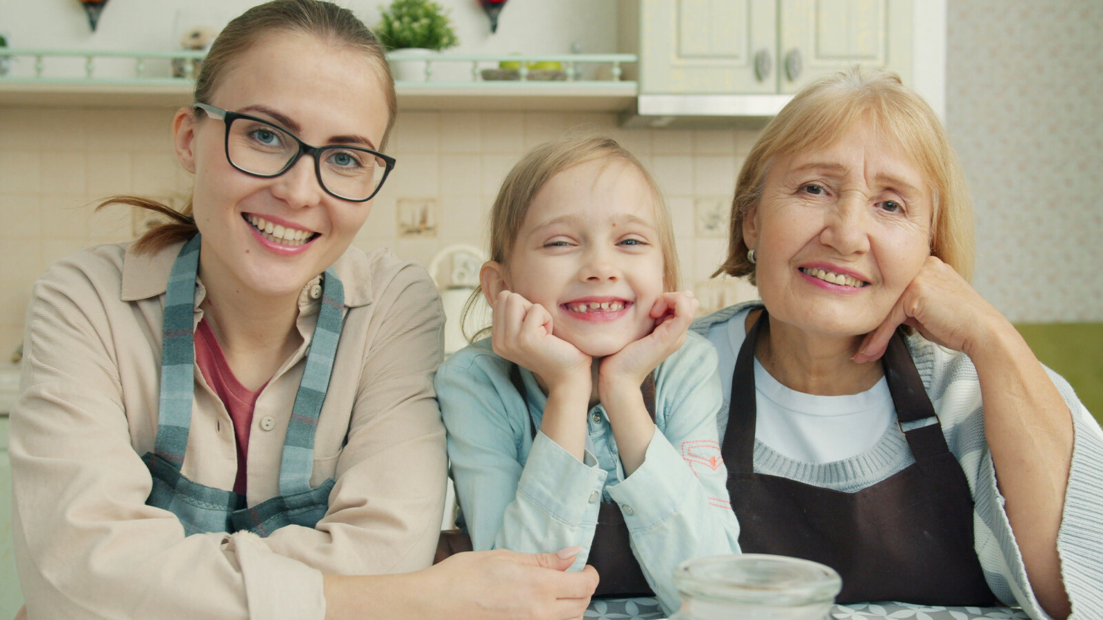 three women of three difference generations smiling at the camera