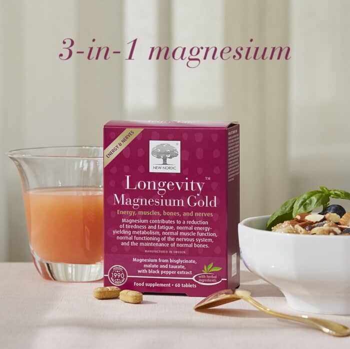 New Nordic Longevity Magnesium Gold™ with a glass of juice, breakfast bowl and tablets, featuring 3-in-1 magnesium.